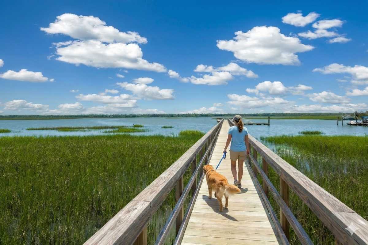 Michelle Almeyda-Wiedemuth adjusting a living room pillow in a Charleston home