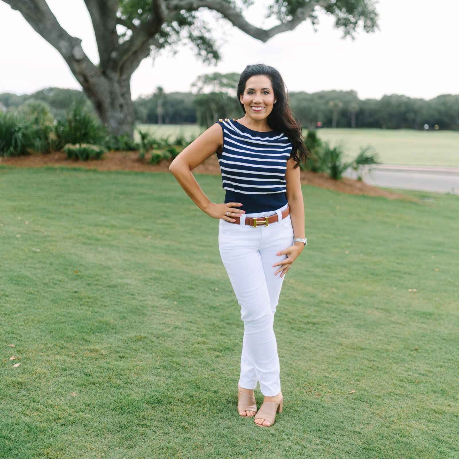 Michelle Almeyda-Wiedemuth holding keys in front of a classic white coastal home, representing the successful transition to the Charleston island lifestyle for her clients.